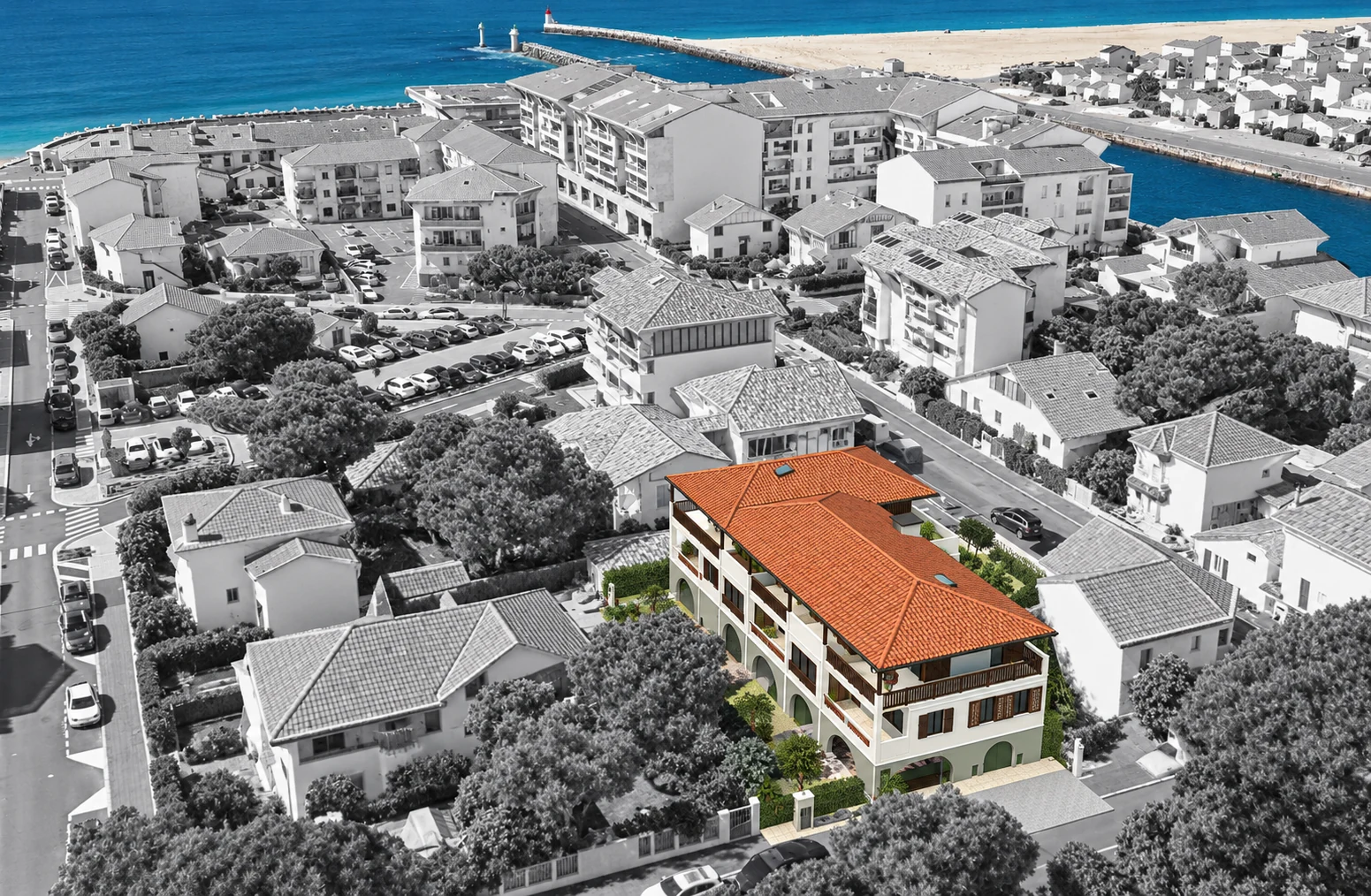 Vue aérienne illustrative de la résidence Albret à Capbreton, en couleur dans son quartier en noir et blanc, avec l’océan bleu